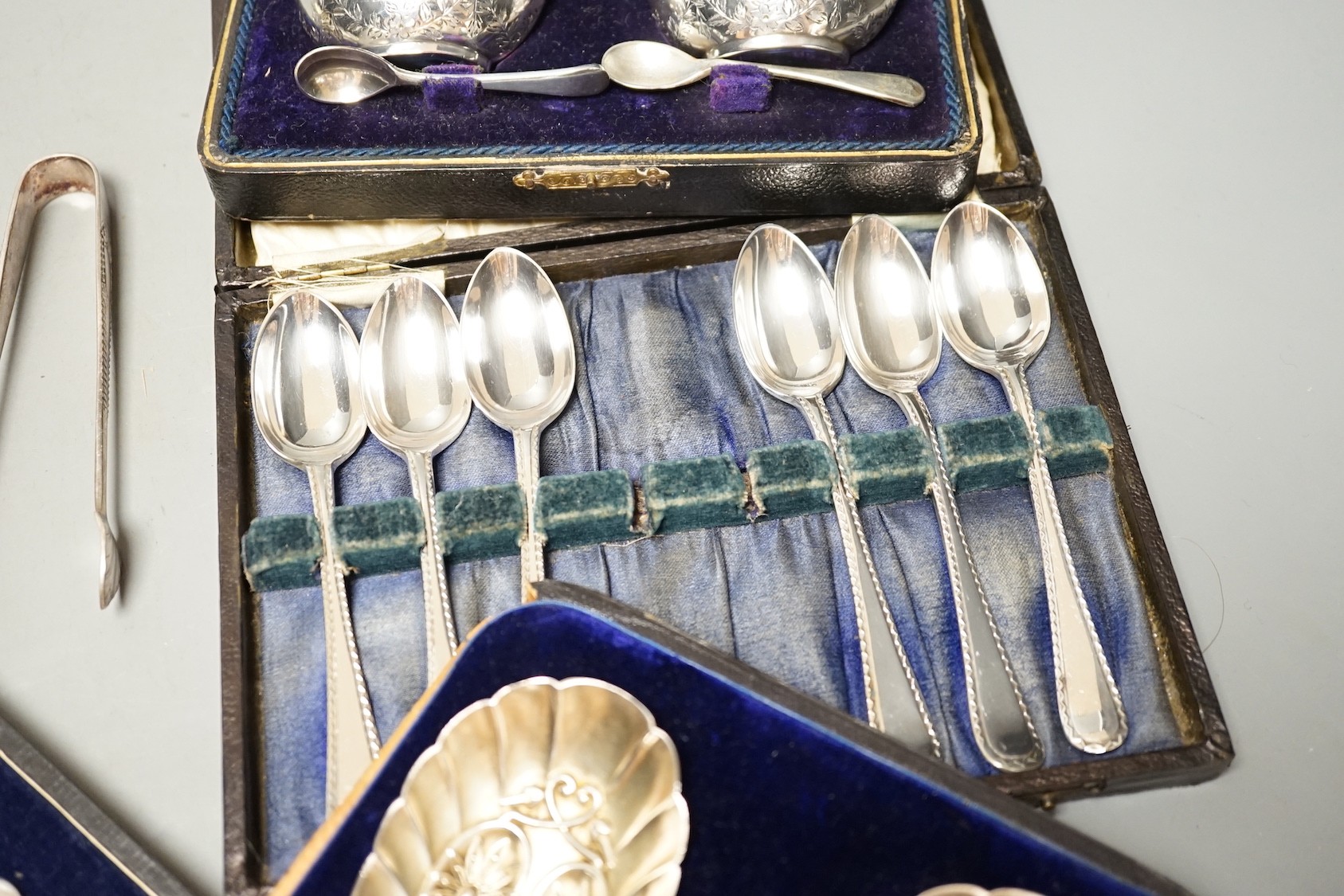 Two pairs of 18th century silver tablespoons including 'berry', a George III silver sifter spoon, pair of sugar tongs and other items including cased plated sets.